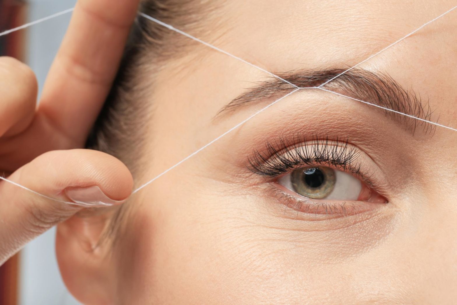 Plucking eyebrows with thread and thread technique